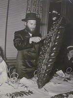 Volvie Stroly cutting challah (from Weiss Bakery)