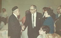 Abe Cohn shaking hands w Arnold Levine at CBS Chanukah Party