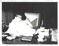 Linda Clutz Cohn working at her father's desk at his office, 1963