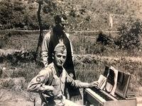 Ellis Schuman playing the piano in the theatre / field